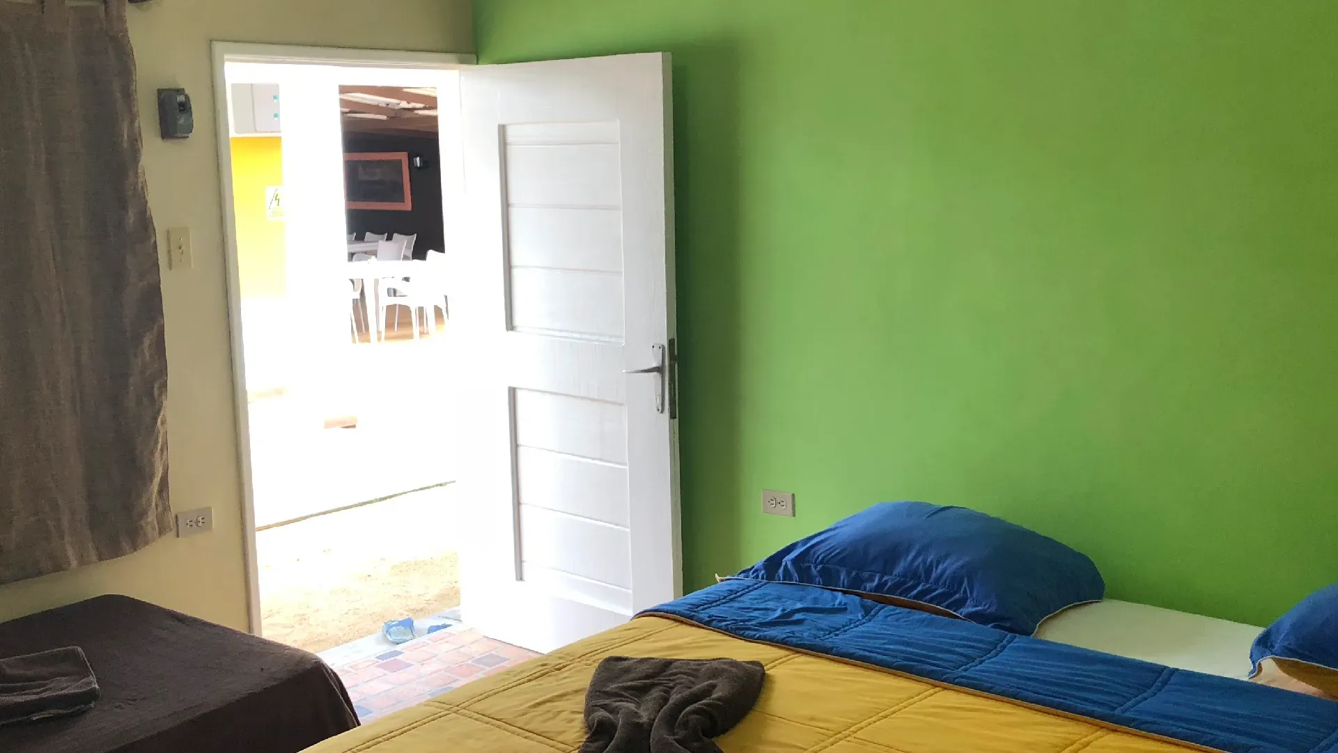 Detalle de la habitación doble: la cama lista, la ventana al mar.